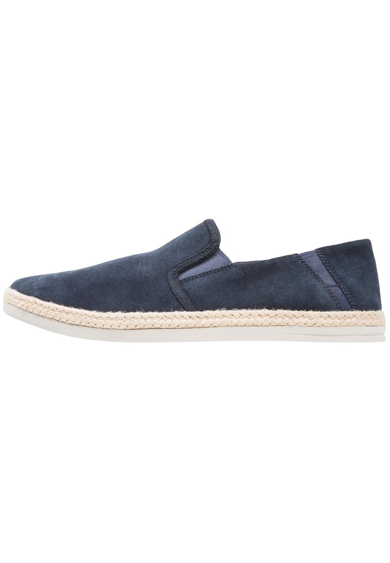 Chaussures slip-on en suede marine avec une semelle en jute de style espadrille. Présente des panneaux latéraux élastiques et une finition lisse semblable à du cuir.