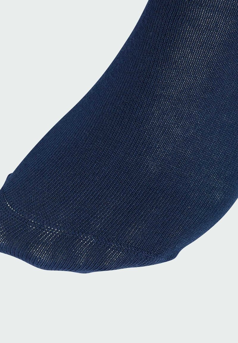 Calzini blu navy realizzati in tessuto testurizzato, caratterizzati da un design elegante e una finitura liscia all'apertura. La vista ravvicinata mette in evidenza le cuciture.