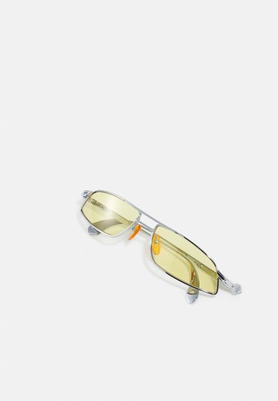 Sunglasses with yellow tinted lenses, metallic silver frame, featuring orange accents on nose pads and a geometric shape.