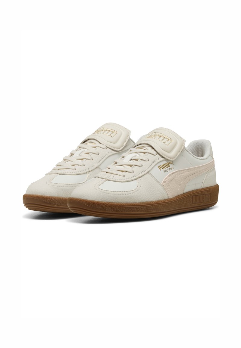 Baskets blanches en cuir avec une finition texturée, dotées d'un bout rond, d'un laçage et d'une semelle en caoutchouc beige. Superpositions douces en beige.