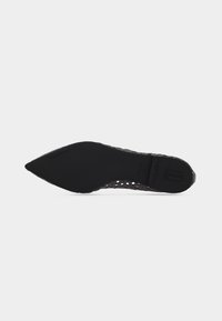 Μαύρο επίπεδο παπούτσι με μυτερή μύτη, εμφανιζόμενο από τη σόλα με κοψίματα κατά μήκος των πλευρών, μέγεθος 37 σημειωμένο στη σόλα.