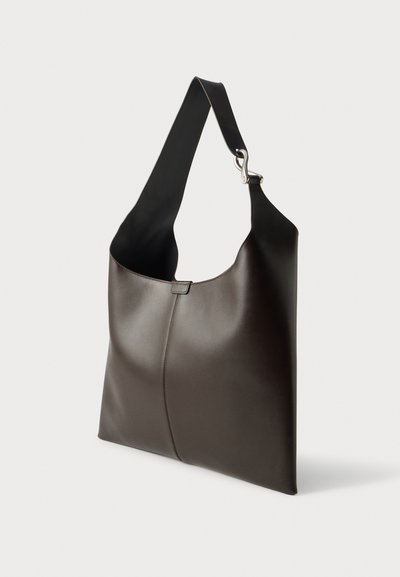 Sac à bandoulière en cuir lisse marron foncé avec une large sangle et une fermeture métallique sur un fond clair uni.