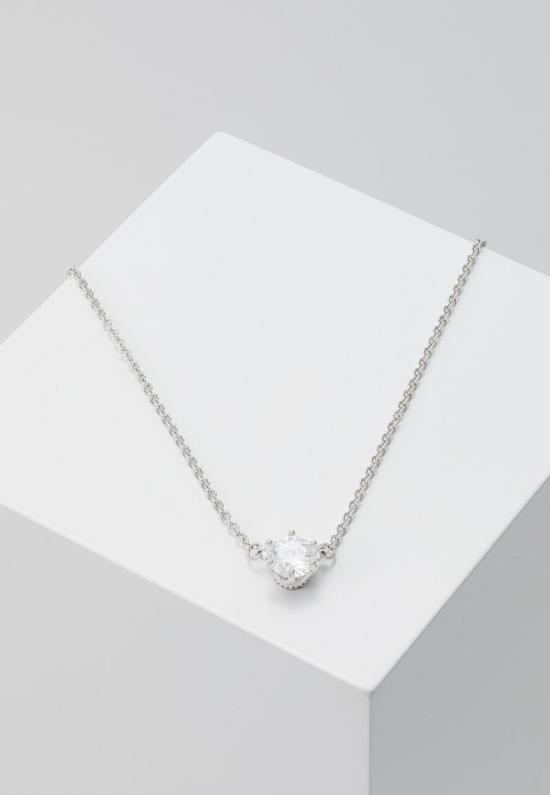 Silver kedja med ett centralt runt slipskärningsstål i en kantsatt fattning. Kedjan har en ömtålig länkdesign.