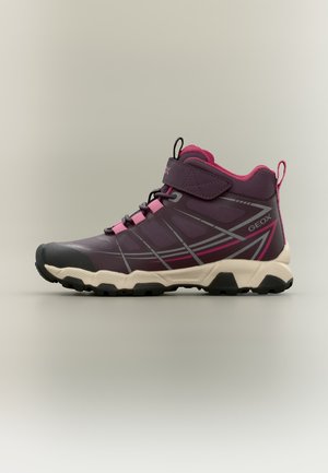 Scarpa da trekking mid-top viola e rosa con suola beige, battistrada nero, strap in velcro e dettagli geometrici sul lato.
