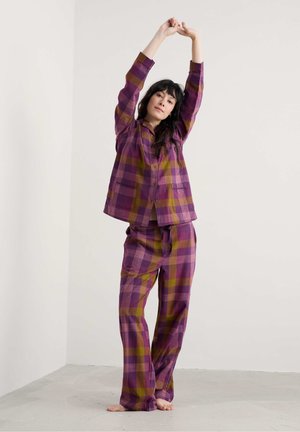 Paarse en gele geruite pyjama set met een knoopsluiting overhemd met zakken en bijpassende elastische broek, gemaakt van zachte stof.