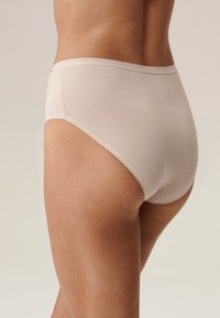 Beżowa bawełniana bielizna typu hipster o gładkiej fakturze, z bezszwowym wykończeniem i subtelnymi szwami przy pasie.