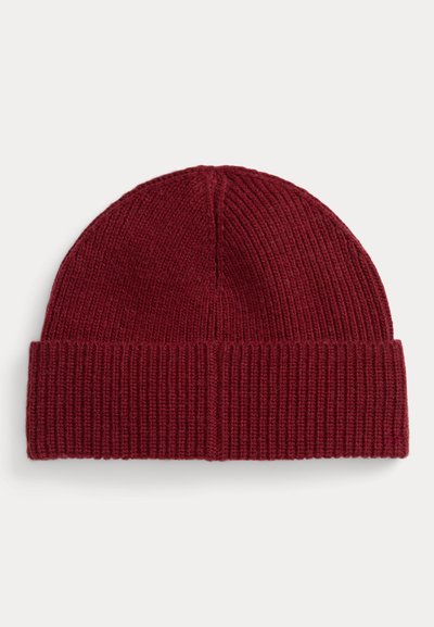 Gorro de malha vermelho com aba dobrada, mostrando textura canelada sobre fundo liso e claro.