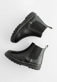Bottes de cheville en cuir noir avec des panneaux latéraux élastiques, une surface texturée, des coutures blanches contrastées et une semelle en caoutchouc robuste.
