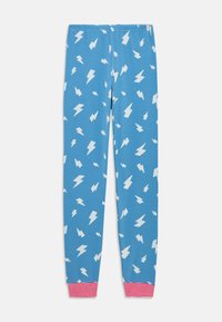 Pantalones de pijama azules con patrones de rayos blancos y puños elásticos a rayas rojas y blancas sobre un fondo blanco.
