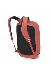 Sac à dos rouge et noir avec des bretelles rembourrées, un extérieur lisse et des boucles latérales ajustables pour un ajustement sécurisé.