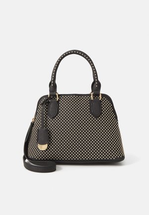 Zwarte leren handtas met gouden studs, dubbele handvatten, afneembare schouderriem en een gouden hanger op een witte achtergrond.