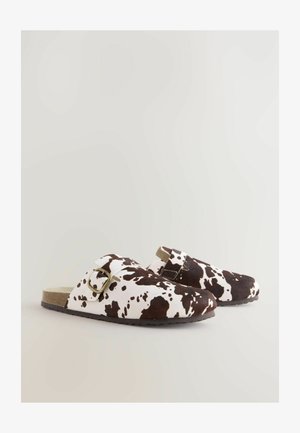 Zoccoli a mocassino con stampa maculata marrone e bianca, dotati di una fascia con fibbia, texture simile al feltro e suola piatta in gomma. Design con punta arrotondata.