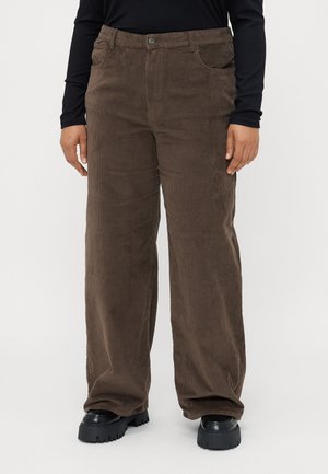 Corduroy bruine broeken met een wijd beenontwerp, voorzien van voorzakken, een knoopsluiting en een zachte textuur. Gedragen met chunky zwarte schoenen.