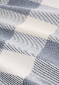 Blauw en crème geblokt stof met een zachte textuur; heeft afwisselende vierkanten met effen en gestreepte patronen in een geweven ontwerp.