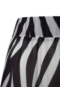 Zwart-witte gestreepte doorschijnende mesh stof met een gathers waistband, met golvende patronen en een lichtgewicht, luchtige textuur.