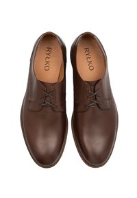 Para brązowych skórzanych półbutów z zaokrąglonym noskiem i beżowymi, wyściełanymi wkładkami marki "RYŁKO", widziana z góry.