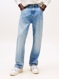 Jeans in denim azzurro chiaro con vestibilità a gamba dritta, dotati di tasche frontali e chiusura a bottone. Indossati con sneakers bianche.