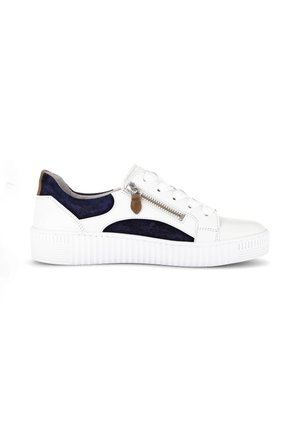 White sneaker with navy blue suede accents, brown pull tab, side zipper, and thick textured sole, shown in profile on a white background.