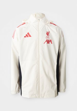 Veste blanche à zip avec capuche, ornée d'accents rouges, du logo de Liverpool et de panneaux latéraux noirs. Fabriquée en matériau léger et lisse.