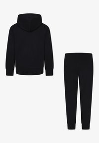 Sweatshirt à capuche noire avec manches longues et poignets côtelés, associé à un pantalon de survêtement noir assorti avec une taille élastique et des ourlets côtelés.