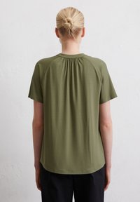 Olijfgroen T-shirt met korte mouwen en een ronde halslijn, met geplooide details aan de achterkant en een soepele textuur.