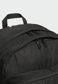 Schwarzer Stoffrucksack mit zwei Reißverschlusstaschen, abgesteppten Details und gepolstertem Tragegriff für einfachen Transport. Strukturierter Stoff.
