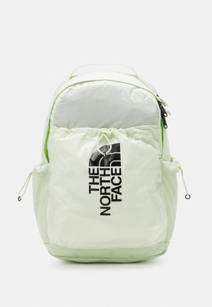 Jasnozielony plecak The North Face z przednią kieszenią na zamek, bocznymi kieszeniami z siateczki, górnym uchwytem i czarnym logo na przedniej kieszeni.