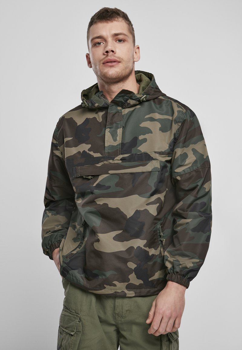 Camouflage pullover jack met capuchon, gemaakt van lichtgewicht materiaal, met elastische boorden, een voorzak en een relaxte pasvorm.