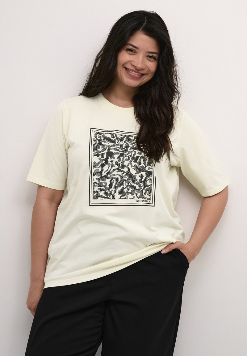 Light yellow short-sleeve t-shirt featuring a black abstract print in a square frame. Relaxed fit with a round neckline.