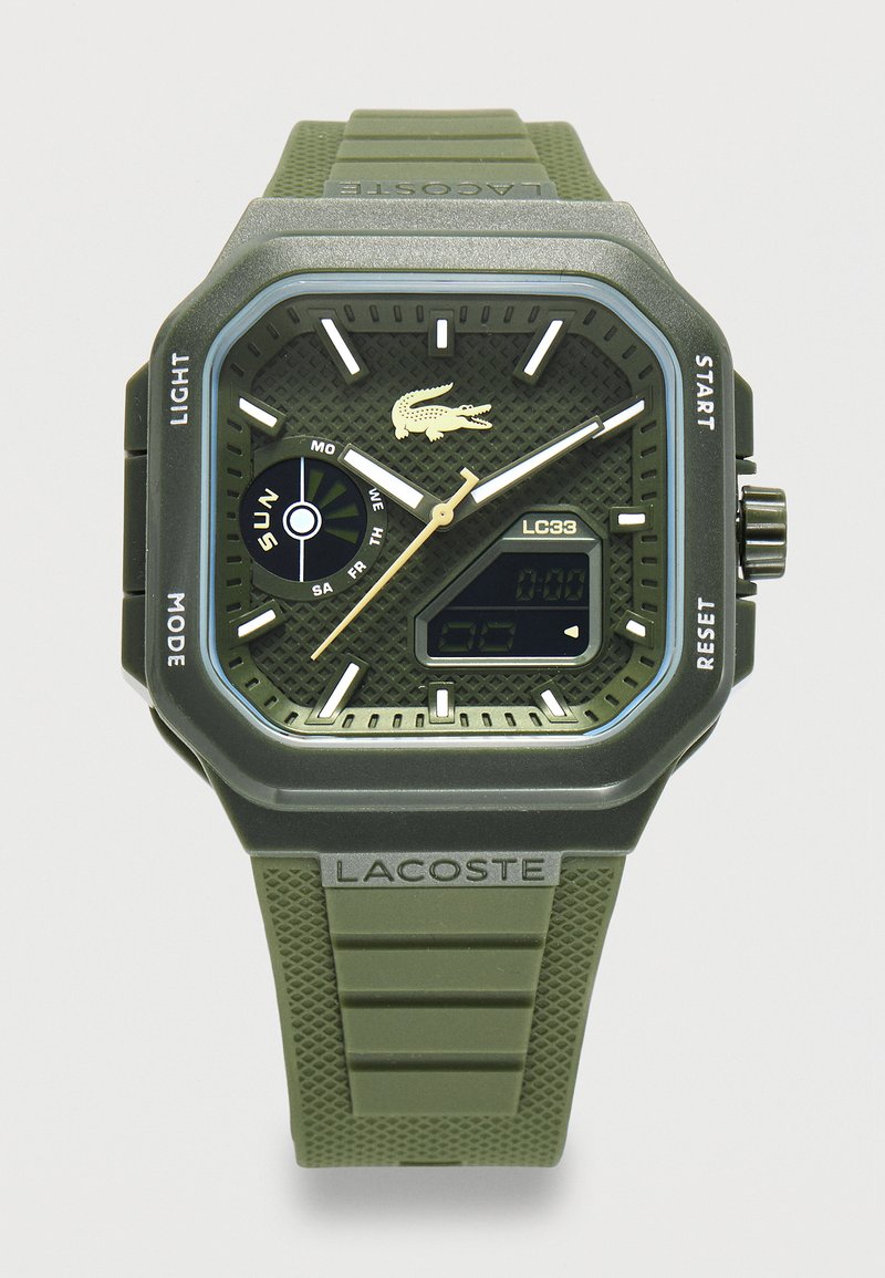 Πράσινο ρολόι χειρός Lacoste με αναλογικούς δείκτες, ψηφιακή οθόνη, ένδειξη ημέρας και υφασμένο λουράκι σιλικόνης.
