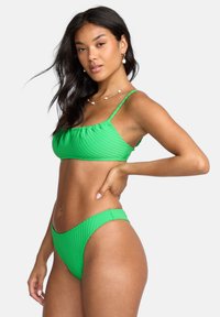 Set bikini verde a coste composto da un top corto con spalline regolabili e un fondo a vita alta abbinato. Tessuto testurizzato con dettagli elastici.