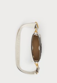 Τσάντα χρώματος κρέμα με δομημένο σχήμα, χρυσές λεπτομέρειες και στενό λουράκι με σχέδιο λογότυπου. Το εσωτερικό είναι από καφέ ύφασμα.