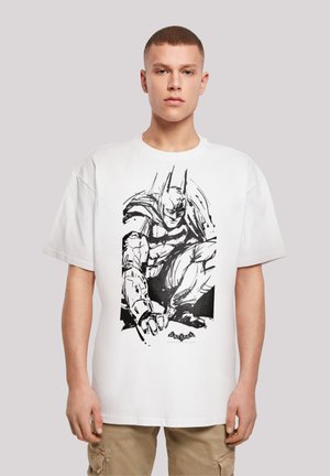 White cotton t-shirt featuring a black and white Batman graphic illustration, showcasing an action pose with detailed lines and shading.