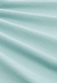 Svijetloplava pamučna tkanina sa glatkom teksturom, koja prikazuje mekane nabore i suptilno sjenčenje koje poboljšava njezinu dubinu i dimenziju.