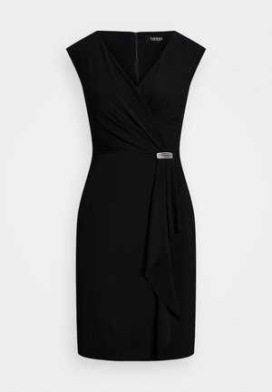 Svart ermela kjole med v-hals, drapert front og asymmetrisk kant. Den har en dekorativ sølvdetalj i livet.