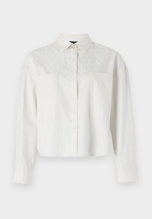 Camicia bianca con bottoni, tagliata, a maniche lunghe, caratterizzata da un discreto motivo a logo sul fronte e due tasche sul petto. Tessuto liscio.