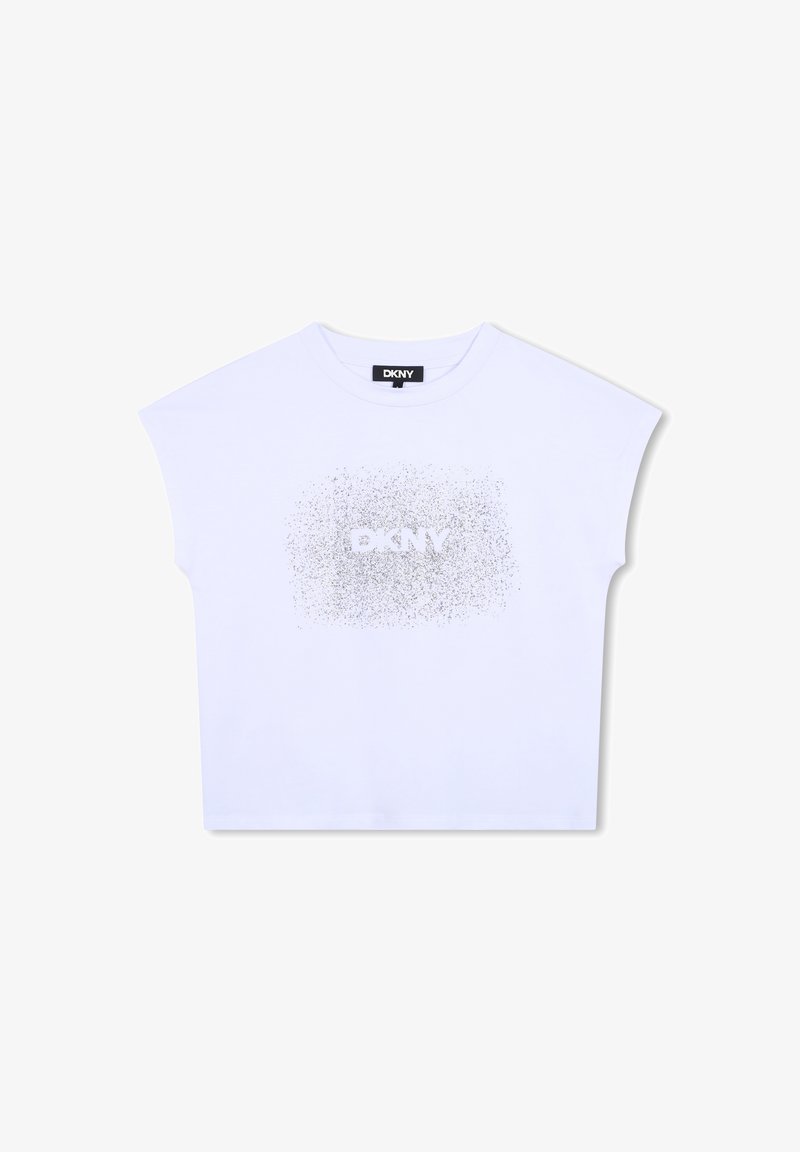 Camiseta blanca cortada con mangas cortas, que presenta un logo plateado brillante de "DKNY" en el centro, hecha de un material de algodón suave.