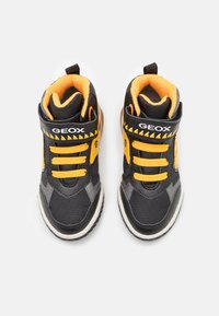 Baskets Geox noires et jaunes avec une tige texturée, des lacets contrastés, un col rembourré et une semelle en caoutchouc avec des accents de logo.