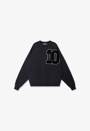 Sweatshirt noir à manches longues, avec des bords-côtes aux poignets et un col rond, présentant un graphique brodé "10 JOURS" en blanc sur le devant.
