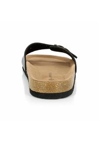 Tongs noires avec un semelle en liège, semelle intérieure texturée beige et une semelle extérieure en caoutchouc noir robuste. Comprend une sangle ajustable avec un accent métallique.