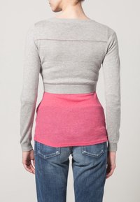 Grå långärmad tröja med ribbad nederkant och rosa nederdel, med ett horisontellt linje-mönster på baksidan och slim fit.