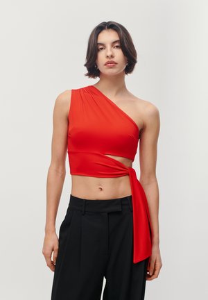 Crvena crop majica s jednim ramenom i prilagođenim dizajnom. Ima bočni izrez i vezani detalj, izrađena je od glatkog, rastezljivog materijala.