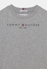 Szara organiczna bawełniana koszulka z okrągłym dekoltem, krótkim rękawem i czarnym napisem "TOMMY HILFIGER EST. 1985" z akcentem logo.