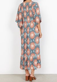 Maxikleid aus blauer Stoff mit einem orangen und weißen Blumenmuster, Kimonoärmeln, geraffter Taille und gestuftem Saum.