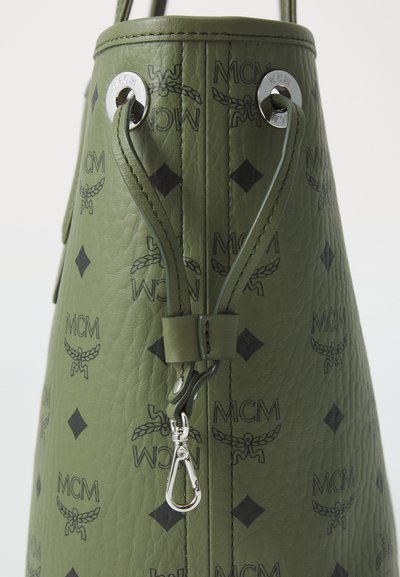 Zielona skórzana torba w formie wiadra z wytłoczonym czarnym logo MCM oraz wzorem w diamenty. Posiada sznurkowe zapięcie i srebrne akcenty hardware.
