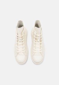 Sneaker alte bianche realizzate in pelle liscia, con lacci dritti, punta arrotondata e collo imbottito. Design minimalista con cuciture discrete.