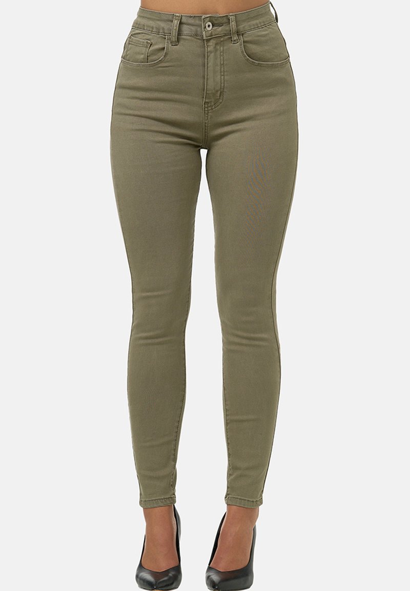 Vaqueros ajustados de cintura alta en tejido de algodón elástico color caqui, con cinco bolsillos y un acabado suave. Combinados con tacones negros.