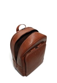 Mochila de cuero marrón con una parte superior redondeada, compartimentos dobles con cremallera y costuras en contraste. Textura suave con un asa resistente.