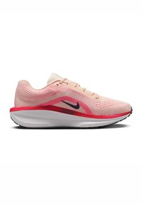 Chaussure de running Nike rose clair et rouge avec empeigne en mesh et logo swoosh noir sur une semelle blanche épaisse, vue de côté.