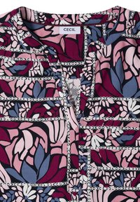 Blouse à motif floral avec des feuilles bordeaux, roses, bleues et blanches, ainsi que des rayures horizontales en forme de chaînes, dotée d'un col rond et d'une ouverture partielle à l'avant.